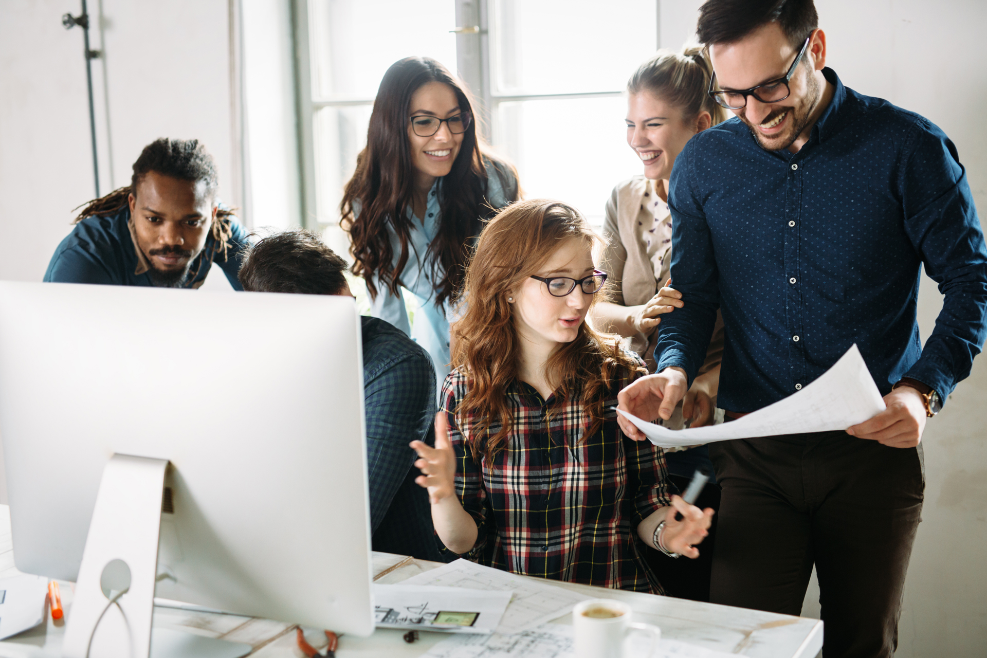 A group of happy people looking at a document